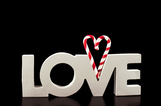large letters LOVE and Heart Lollipop isolated on black - Stock