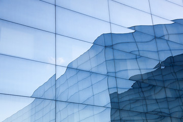 Wall Mural - facade of modern glass building with reflections of blue sky and