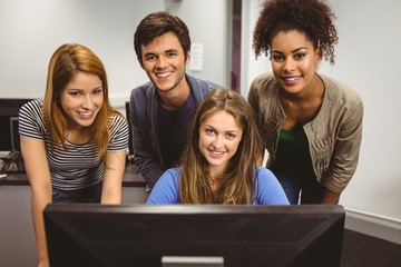 Poster - Smiling students using computer together looking at camera