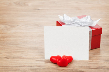 Blank valentines greeting card, gift box and red candy hearts