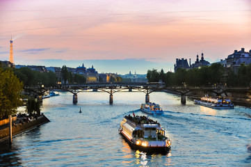 tour boats on seine at sunset