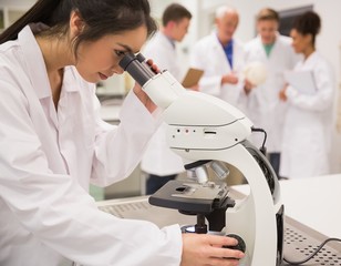 Wall Mural - young medical student working with microscope