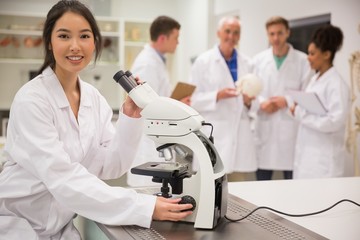 Wall Mural - young medical student working with microscope