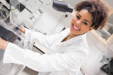 Wall Mural - pretty science student using microscope
