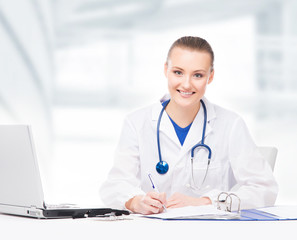 Wall Mural - Young, professional and cheerful female doctor working in office