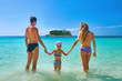 © soft_light - Happy family standing on the beach at the day time