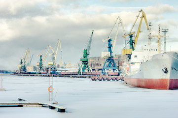 The ship is in port cranes on a background of winter