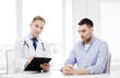 © Syda Productions - doctor with clipboard and patient in hospital