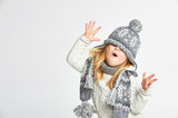 Fototapeta Uliczki - Beautiful blond girl playing in the winter warm hat and scarf on