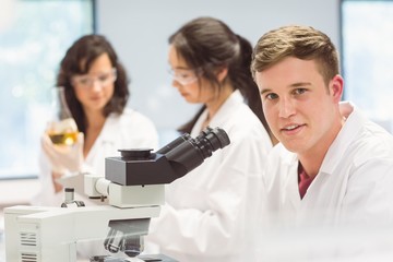Wall Mural - science student looking through microscope in the lab