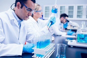 science student using pipette in the lab to fill test tubes