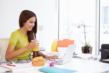 Wall Mural - Woman Working In Design Studio Having Lunch At Desk