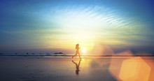 Young Girl Running Along The Beach.