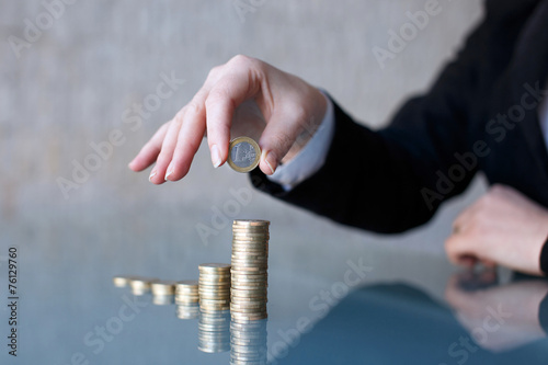 Fotografía Businesswoman building growing one euro columns closeup