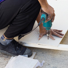 Wall Mural - carpenter hands using electric drill on wood