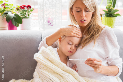Fotografia Mother checking temperature of her sick child