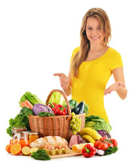 Fototapete - Young woman with assorted grocery products isolated on white