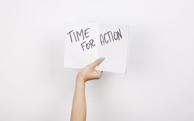 Female hand holding notebook with time for action quote
