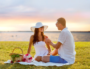 Wall Mural - smiling couple with small red gift box on picnic