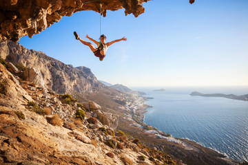 Wall Mural - Female rock climber falling of a cliff while lead climbing