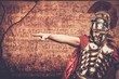 Roman legionary soldier in front of  wall with ancient writing