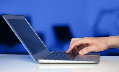 Businessman pressing modern laptop computer on colorful backgrou