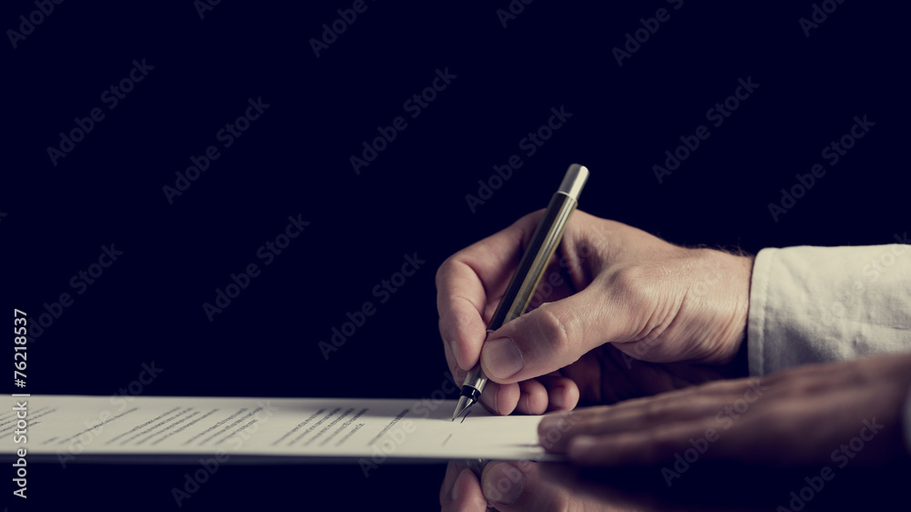 Signing a contract over dark background - obrazy, fototapety, plakaty 
