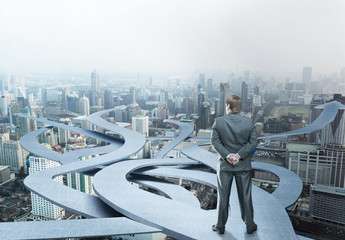 Businessman stands choosing his way