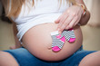 © Artsaba Family - belly of pregnant woman with baby socks