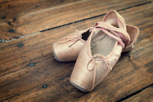 Old Pink Ballet Shoes On A Wooden Floor, Vintage Process