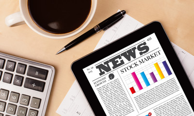 Wall Mural - tablet pc shows news on screen with a cup of coffee on a desk