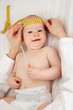 Kinderaerztin misst Kopfumfang eines Babys Ausschnitt