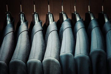 row of men suit jackets on hangers