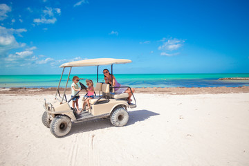 Wall Mural - Little girls and their mother driving golf cart at tropical