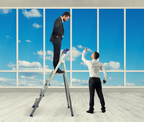 Canvas Print - man standing on stepladder and looking