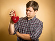 handsome man looking suspiciously on decorative red heart