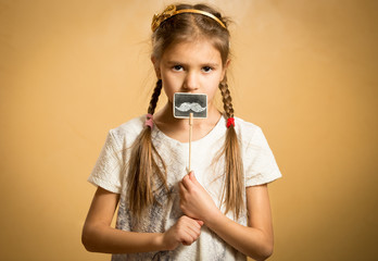 cute girl holding funny decorative mustaches