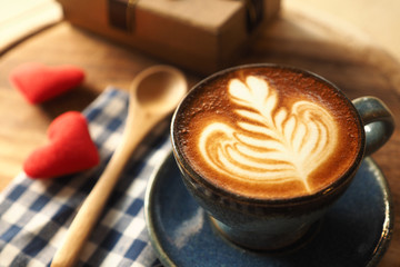 vintage color tone of  cup of coffee with red heart on the table