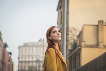 Wall Mural - Redhead girl posing in the city streets