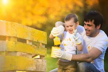 Father and son painting fence