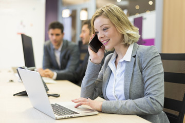 Businesswoman talking on the mobile phone in modern office