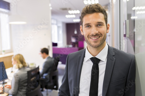 Fotografie, Obraz Portrait of smiling Businessman posing in modern office, lookin