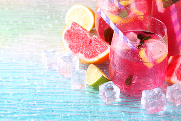 Pink lemonade in glasses and pitcher on bright background