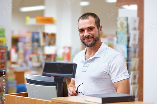 Salesman at the checkout in a bookstore Tableau sur Toile