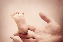 Baby Feet In Mans Hand