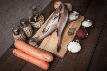 Wall Mural - Still life with fish, vegetables and spices on a wooden board. T