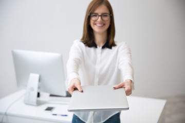 Canvas Print - Happy businesswoman giving laptop on camera. Focus on laptop