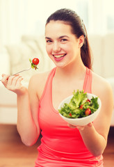 Canvas Print - smiling teenage girl with green salad at home