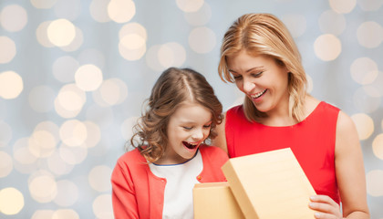 Canvas Print - happy mother and daughter opening gift box