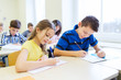 © Syda Productions - group of school kids writing test in classroom